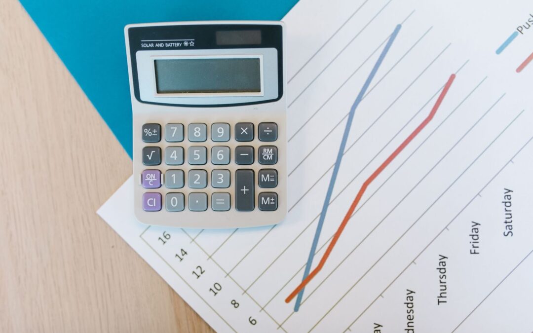 Top view of calculator and graph paper on office desk, perfect for business themed visuals.